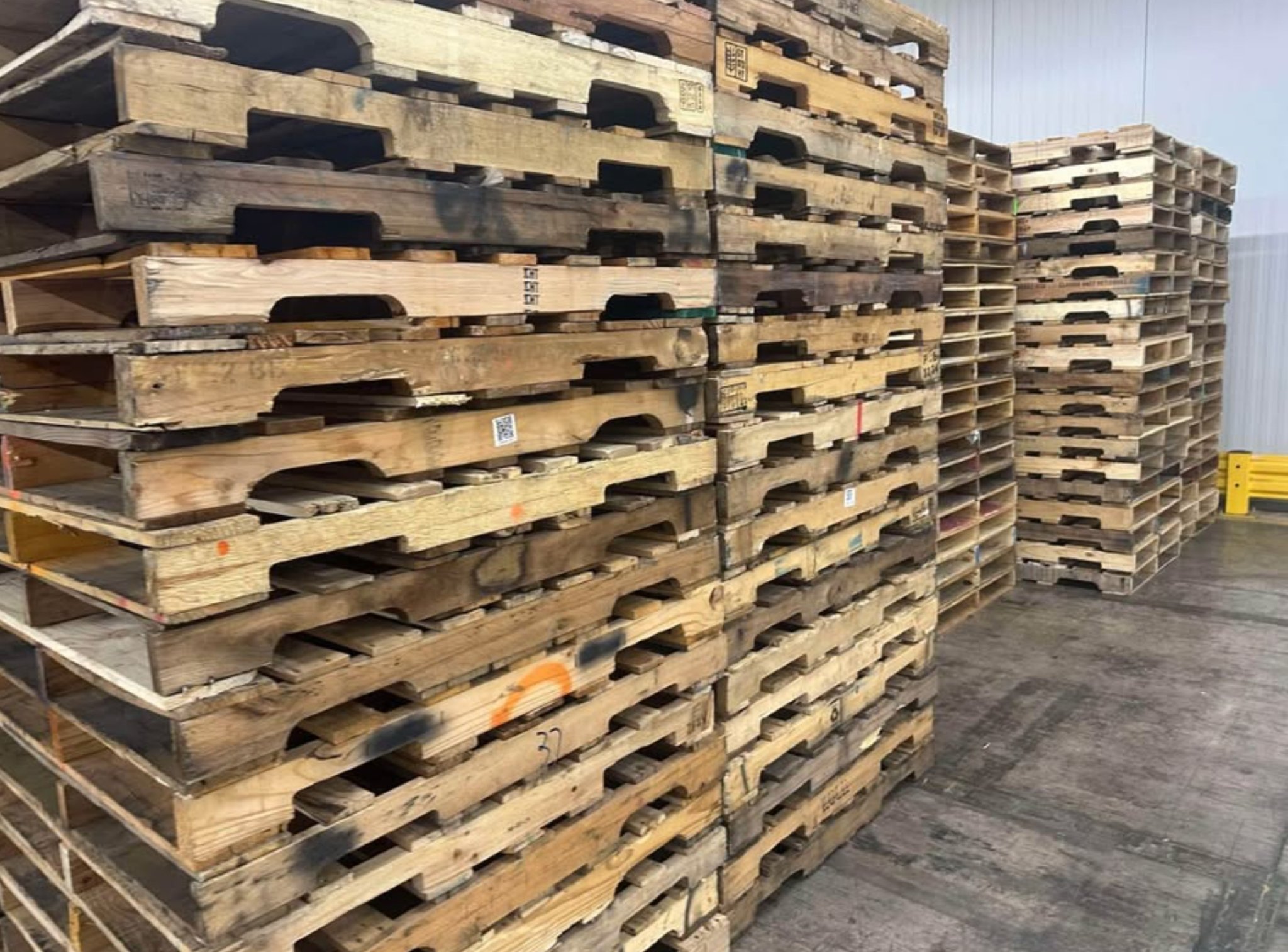 Stacks of B Grade used wooden pallets