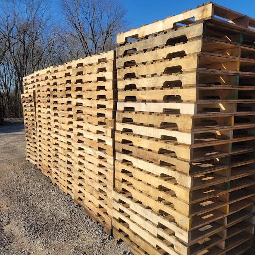 Stacked A Grade 48 by 40 used wooden pallets outdoors